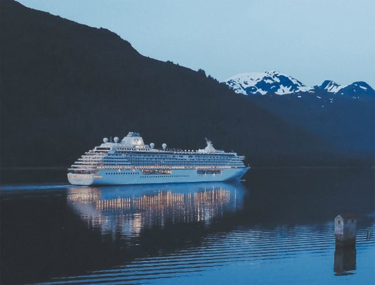 cruise ship sailing past mountains
